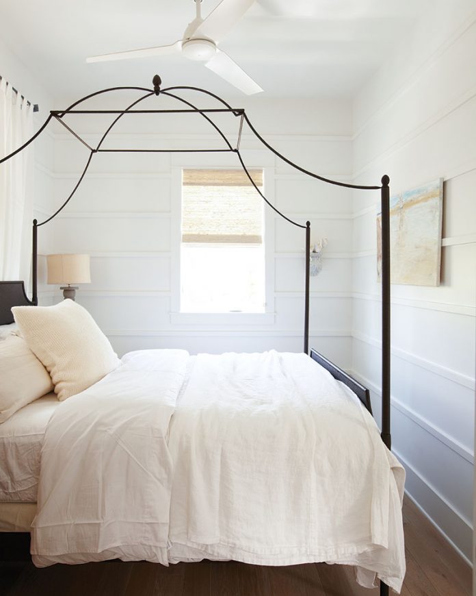 White bedrrom with black iron canopy bed