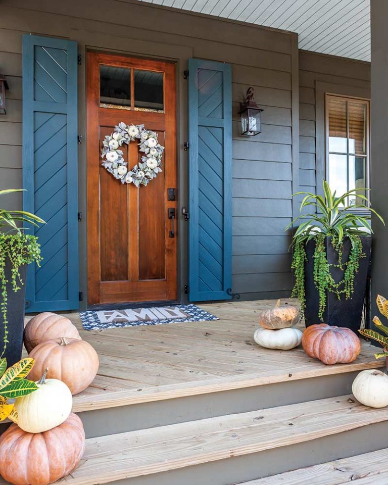 front door with blue shutters and pumpkins