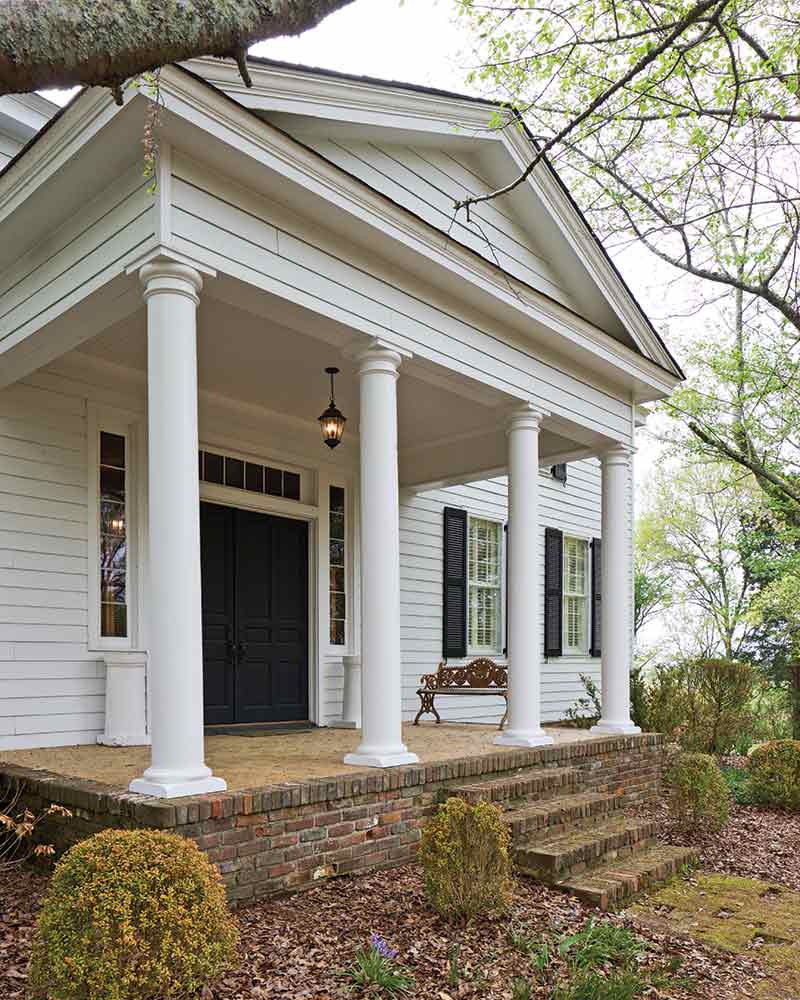 country home exterior - white columns and black front door