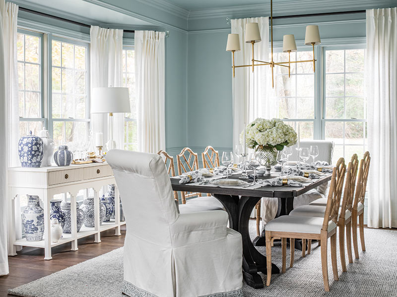 A dining room decorated in blue and white with chinoiserie ginger jars.
