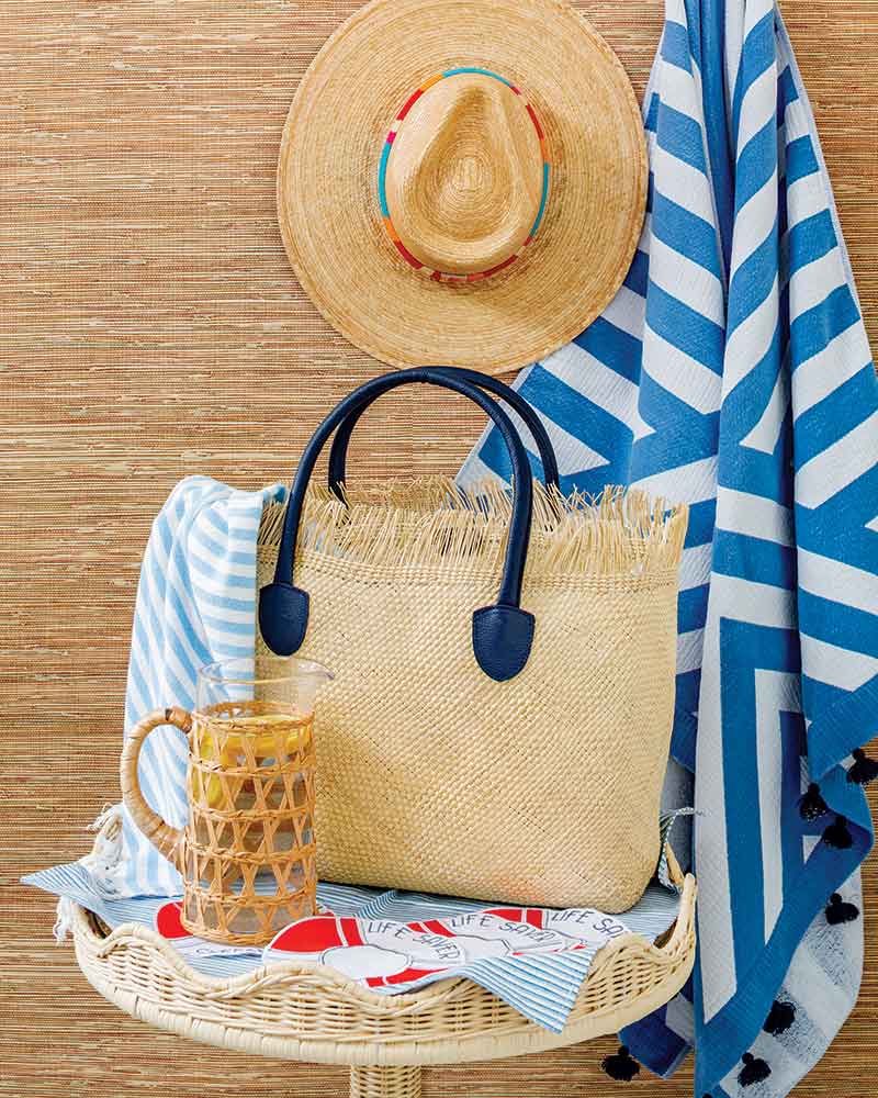 A beach bag with a towel and straw hat.