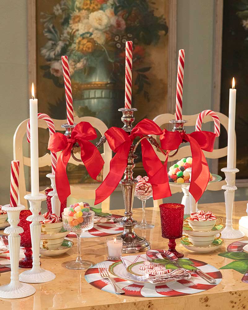 A silver candelabra with red bows. 