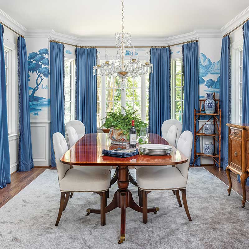 Dining room with hand-painted mural and blue draperies.