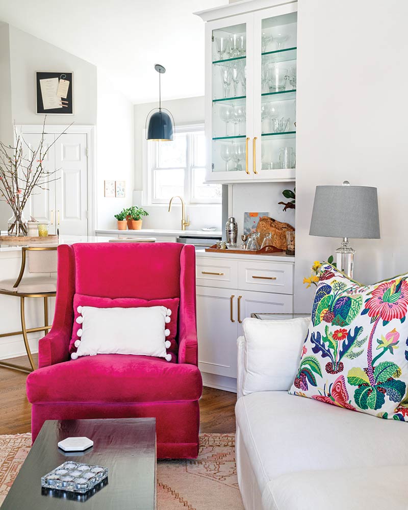 A pink velvet armchair in a white living room.