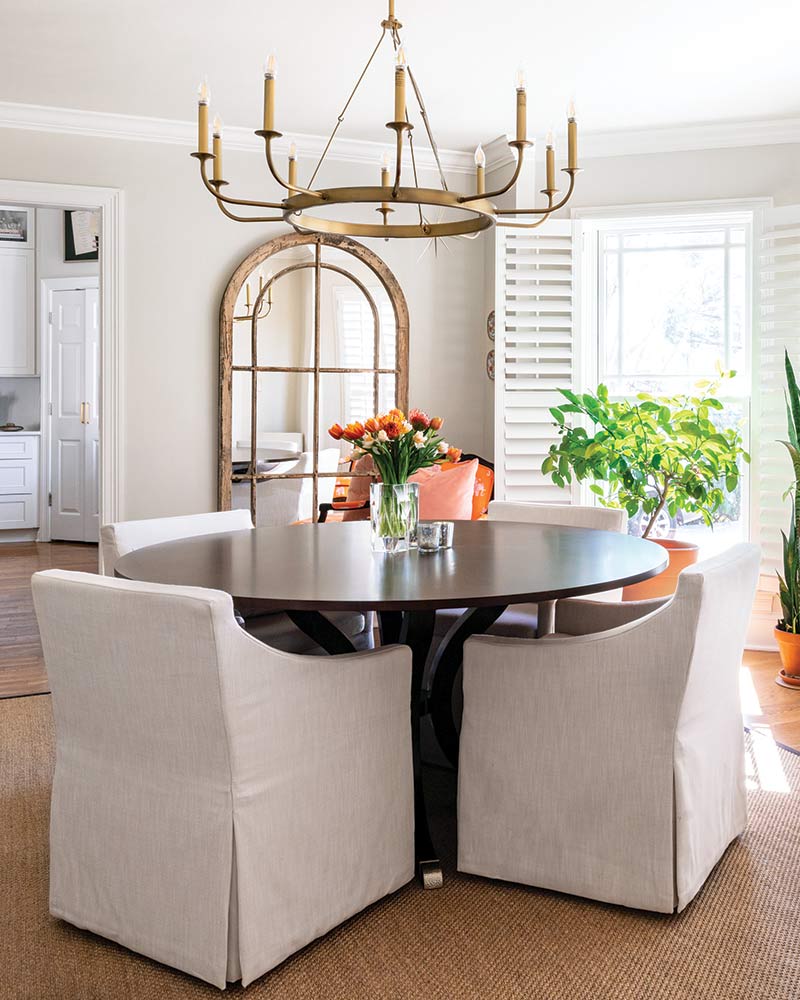 A dining room decorated in contemporary style with neutral, orange, and peach tones. 