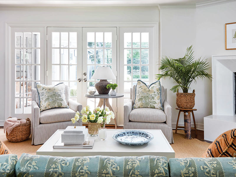 A living room with a patterned sofa and pillows with a botanical print.