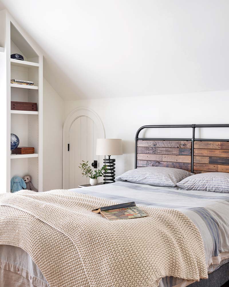 A bedroom with a creamy yellow knit throw. 