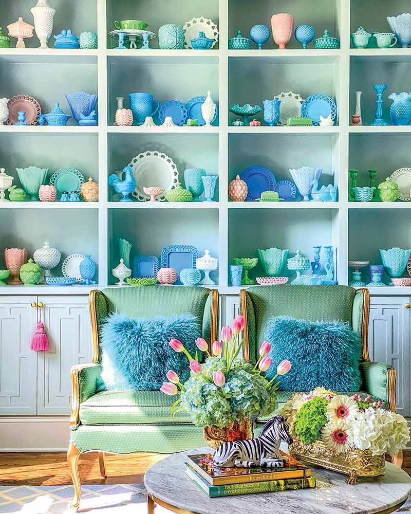 A wall of built-ins with a collection of vibrant vintage milk glass.