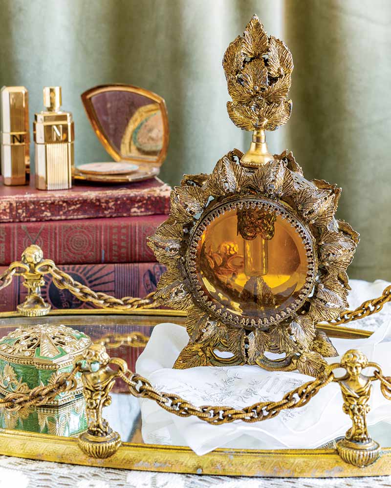 An antique perfume bottle on a mirrored tray.