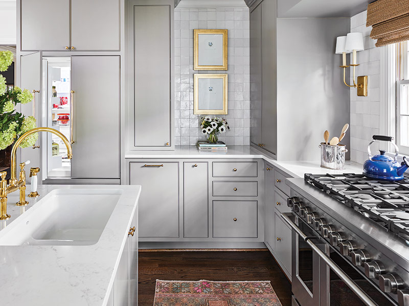 a kitchen with gray cabinets, white counters, and a white tile backsplash.