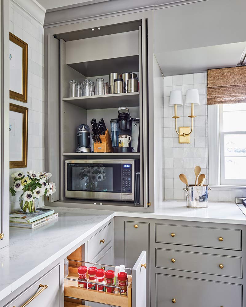 A kitchen with a spice drawer near the oven and an appliance garage. 