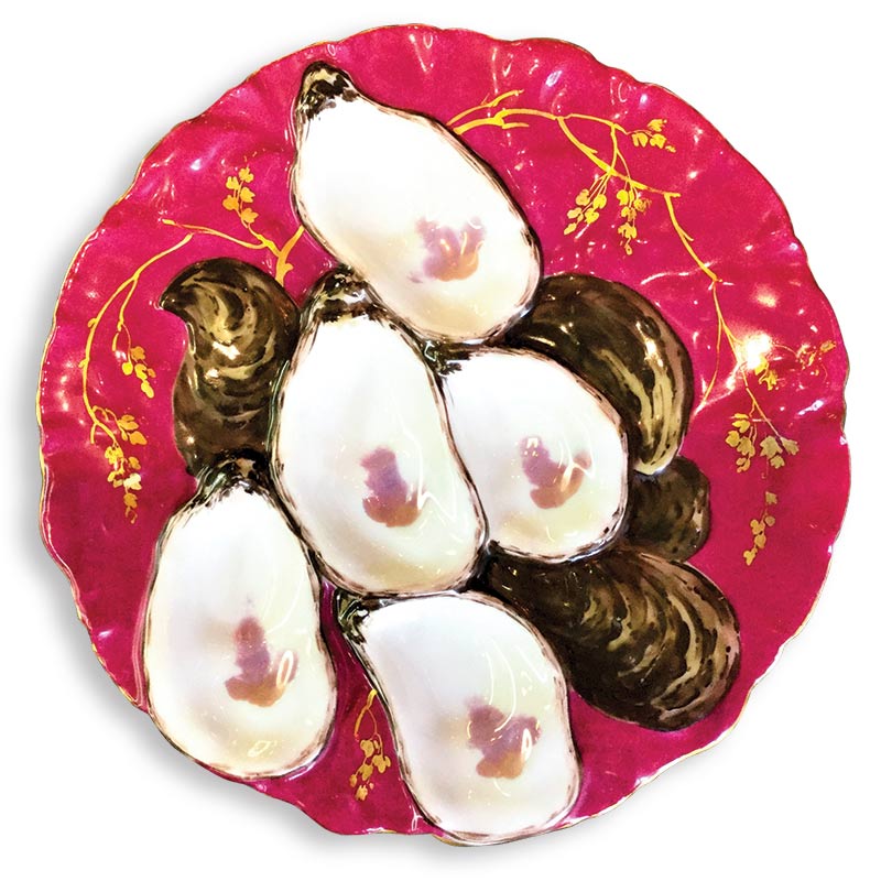 A vibrant pink turkey-shaped oyster plate decorated with golden floral patterns. 