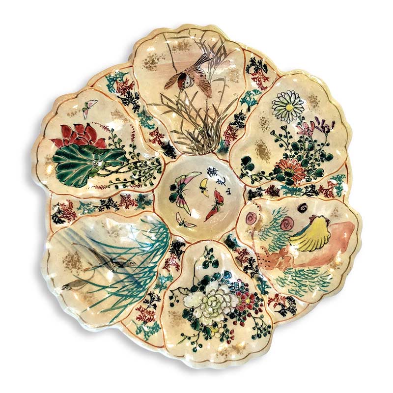 Ornate oyster plate featuring a scalloped edge and divided into sections, each painted with vibrant, distinct floral and bird designs, set against a white background.