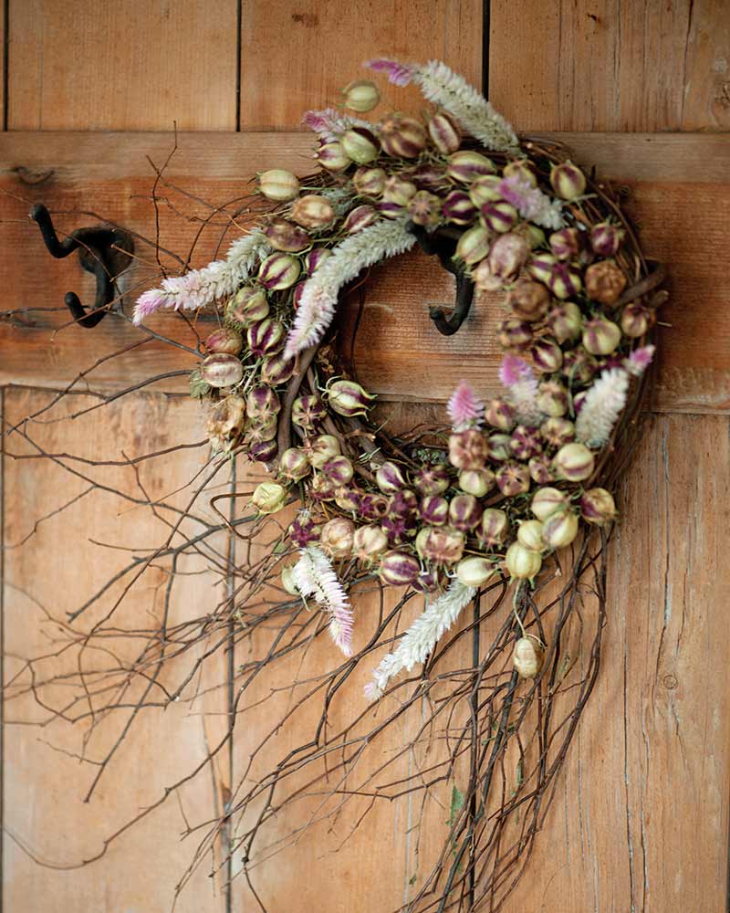 A rustic autumn wreath with grapevine branches and seedpods. 