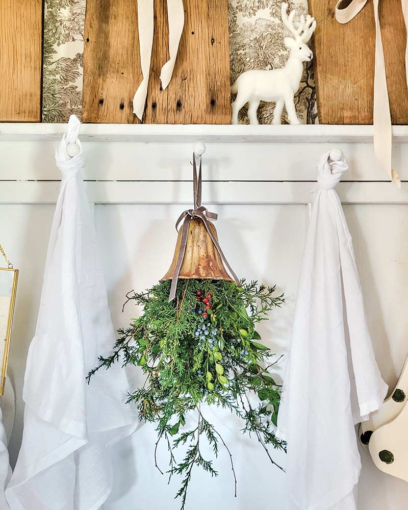 A mistletoe arrangement hanging on a kitchen hook. 