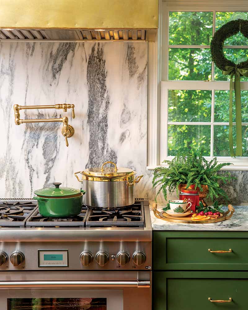 The Miller family was very keen on the British racing green color for the cabinets, and paired with the brass details, their holiday decorations fit perfectly with the kitchen design.