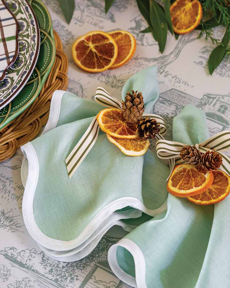 The true charm of a country-style Christmas is an appreciation for nature’s beauty. Welcome it to the table with pine cones and dried orange slices, which offer the added benefit of filling your home with an alluring seasonal aroma.