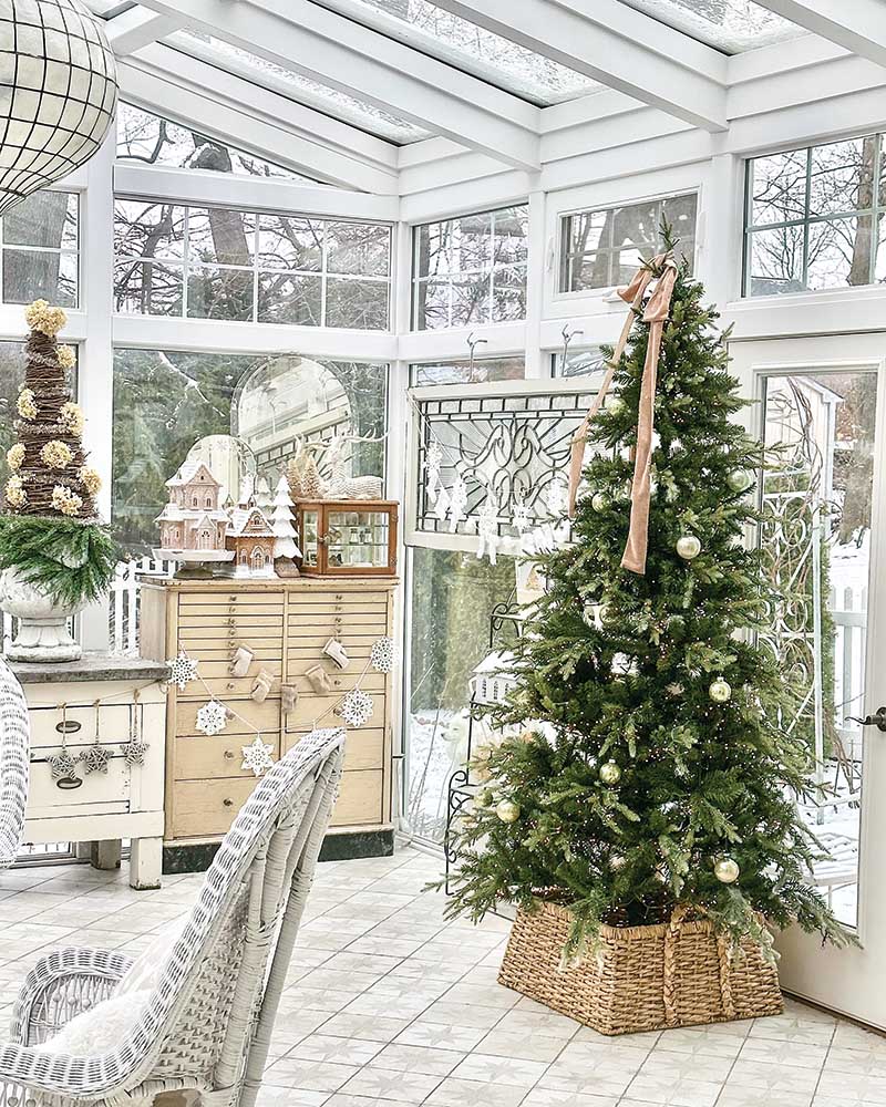 In lieu of a traditional tree skirt, opt for an oversize woven basket to lend natural warmth and an unexpected touch of country charm. Scatter a few ornaments throughout the tree’s branches for a less-is-more approach, topping the tree off with a beautiful bow.