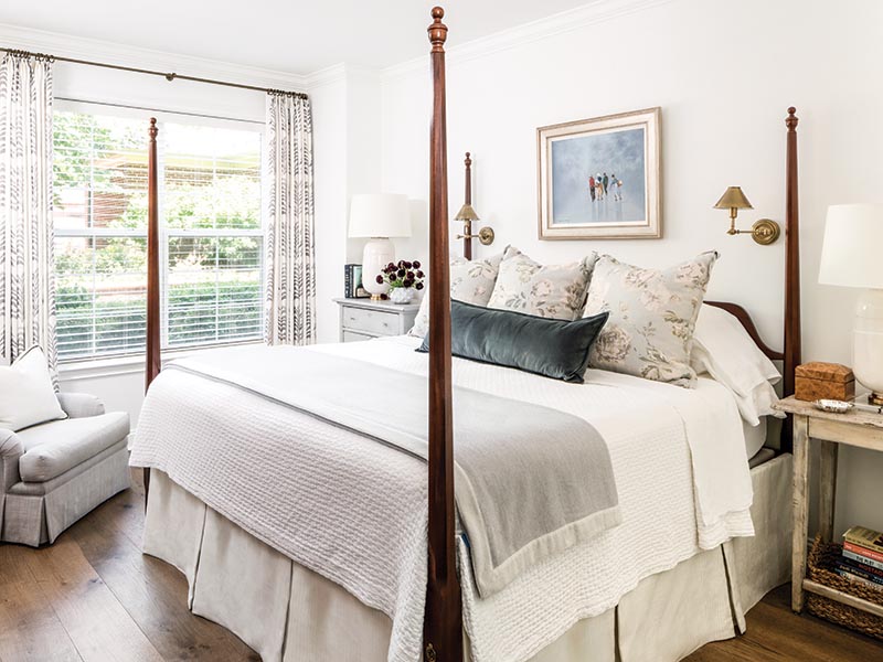 A four-poster bed features bedding by Annie Selke with custom shams in a soft floral print from Madeaux by Richard Smith.