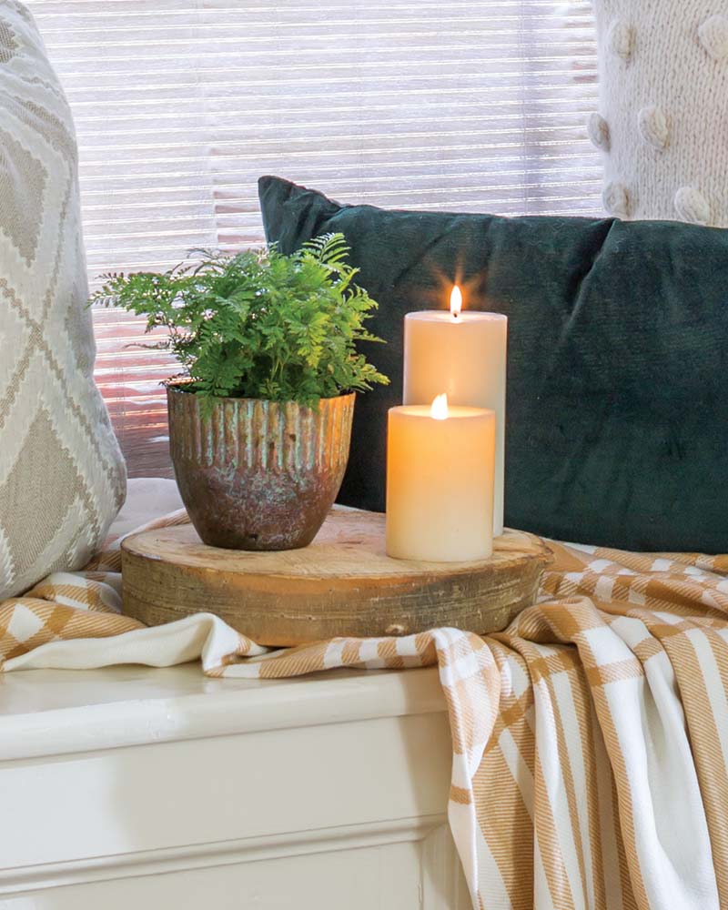Instantly enrich year-round décor like small houseplants by pairing them with soft linens and simple glowing candles.