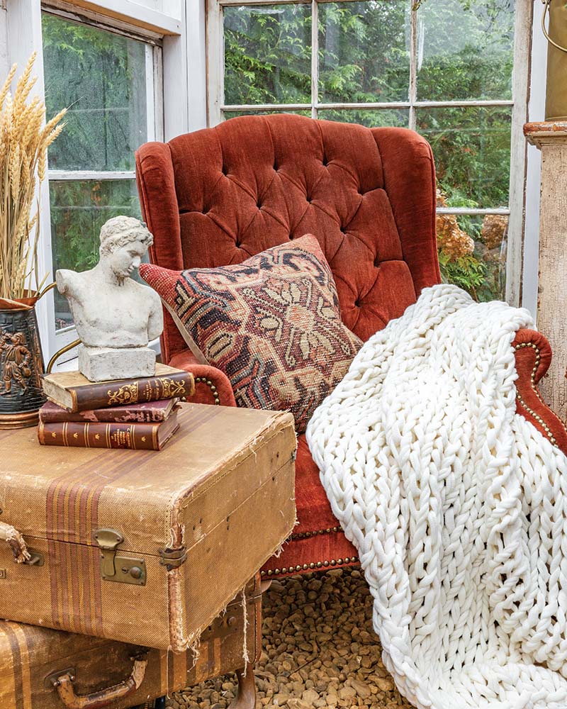 Bring your collectibles outdoors to warm up areas such as a greenhouse, where layers of comfortable furnishings and thoughtful touches lend an air of coziness.