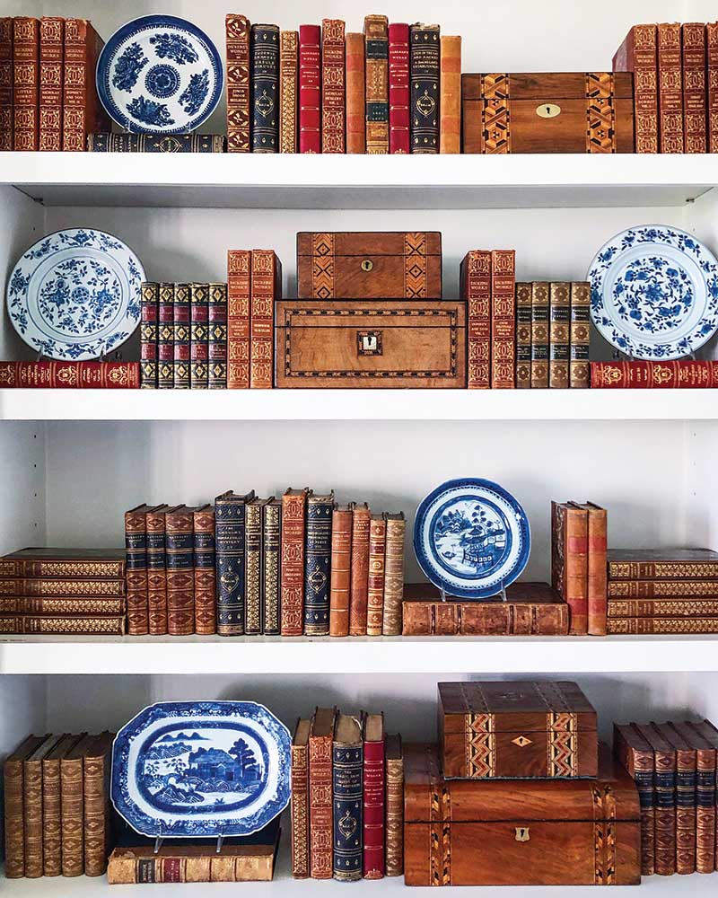 By alternating vertical and horizontal placement of your books, you can create separate vignettes within the larger styled moment. Emphasize visual interest by topping off a few with blue-and-white china that provides showstopping contrast.