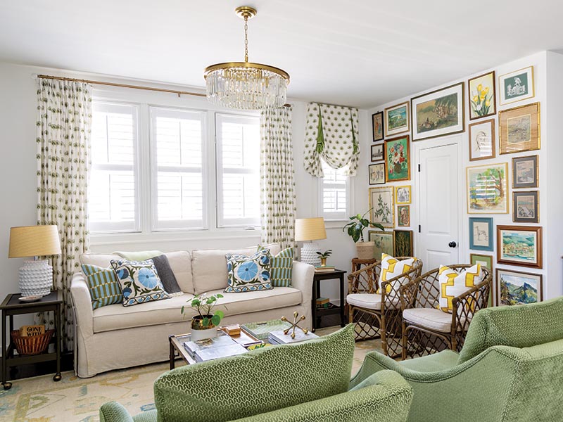 The feminine motifs of the living and dining spaces give way to a vibrant mid-century-inspired aesthetic in the upstairs den, where block prints join geometric patterns and rattan chairs offset a vintage brass-and-glass coffee table.
