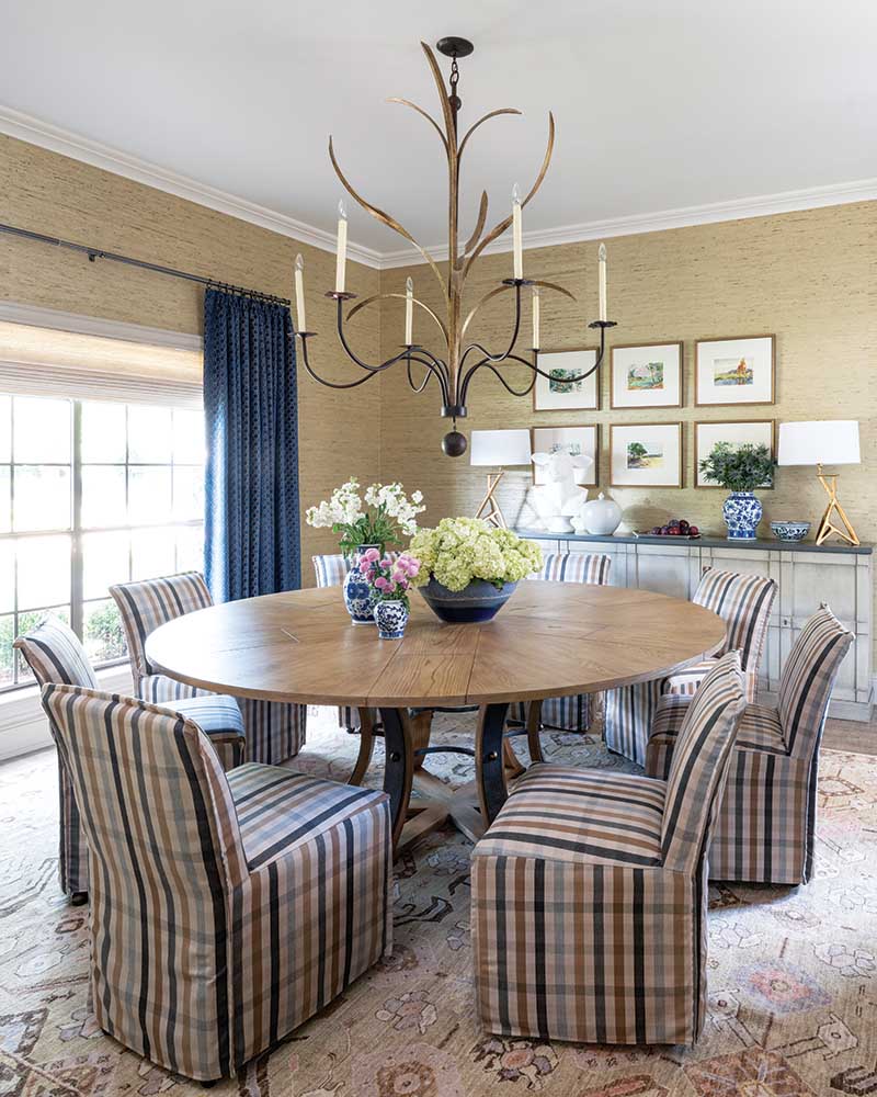 The right light fixture can transform a room—which is certainly the case in the dining room, where a chandelier from Lowcountry Originals serves as a true centerpiece. Below, a 72-inch round dining table fills the space, surrounded by chairs upholstered in a LEE fabric.