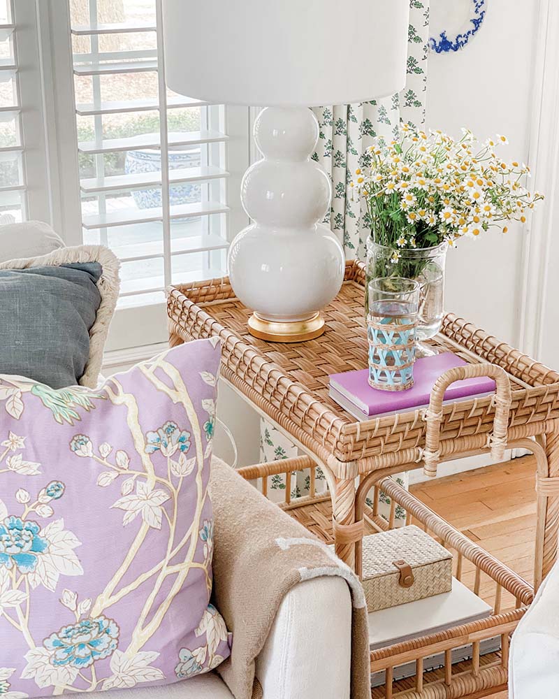 Natural woven pieces like end tables and ottomans contribute warmth to the pared-down, sophisticated palette.