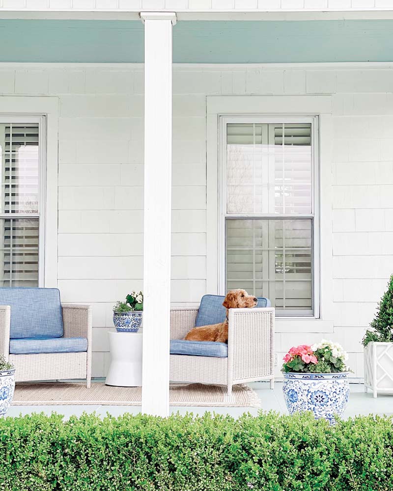 Maggie brightened up the home’s exterior spaces, which feature original shingle in places, with fresh paint and touches of chinoiserie. In a creative twist on a classic, the haint blue of the porch ceiling is reflected on the floorboards.