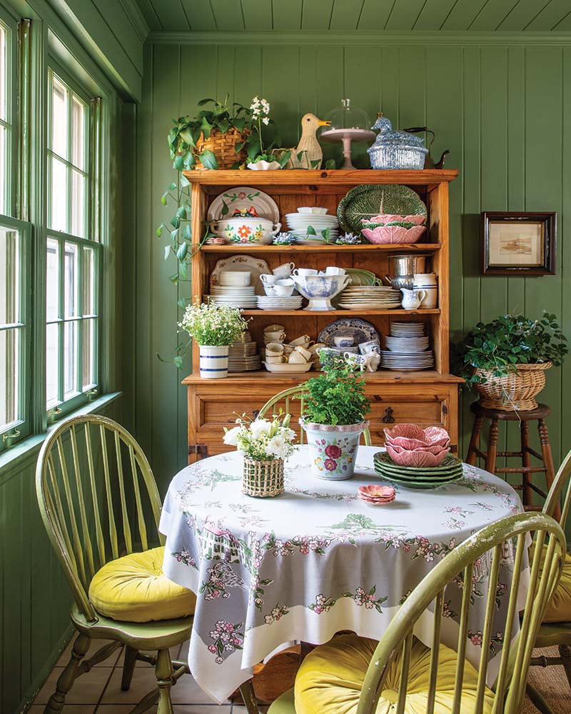 Washed in Farrow & Ball’s Calke Green, the dogtrot doubles as their breakfast room, where her favorite collections of dishes—from pink and green cabbageware to Lochs of Scotland—are artfully displayed among the shelves of the pine hutch.