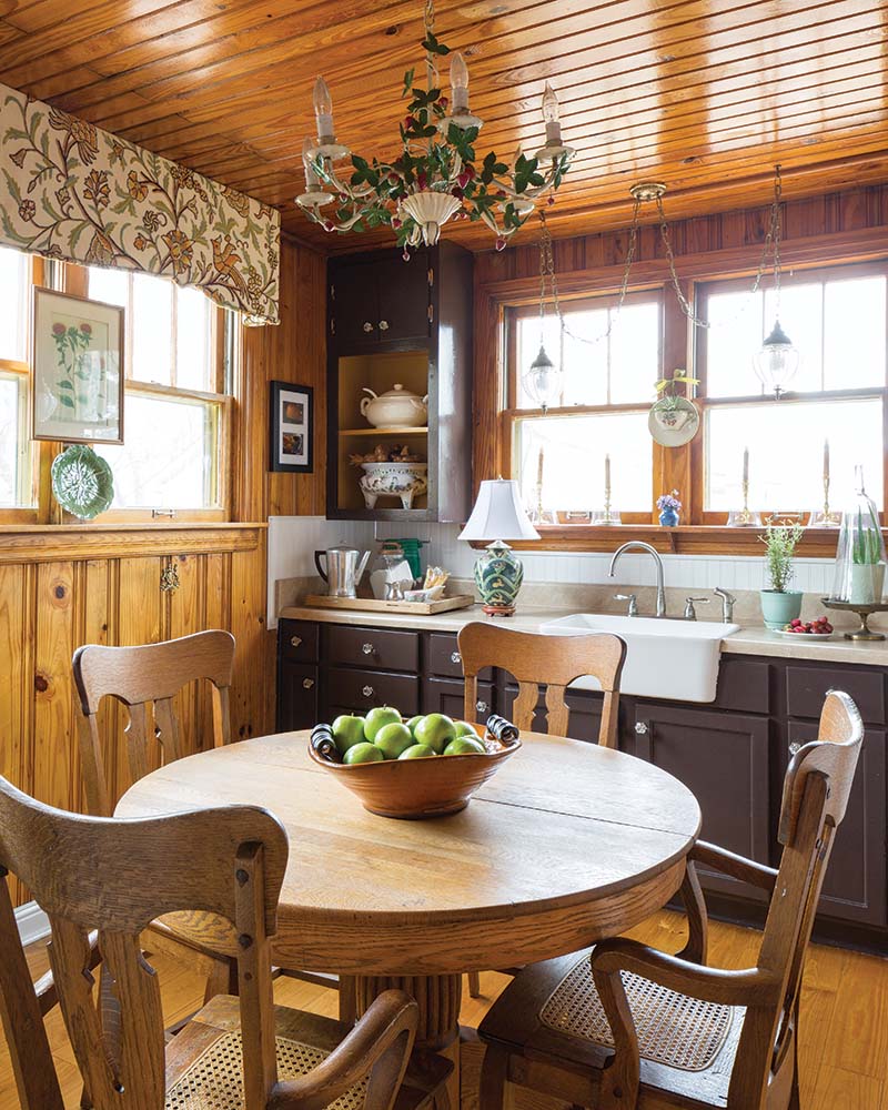 “It reminds me of my grandmother’s house, so I haven’t touched the kitchen,” she says, pointing out the yellow pine paneling that many would have opted to paint. Instead, she has filled the space with pieces that complement its classic style, like the tole chandelier and vintage silver pieces.