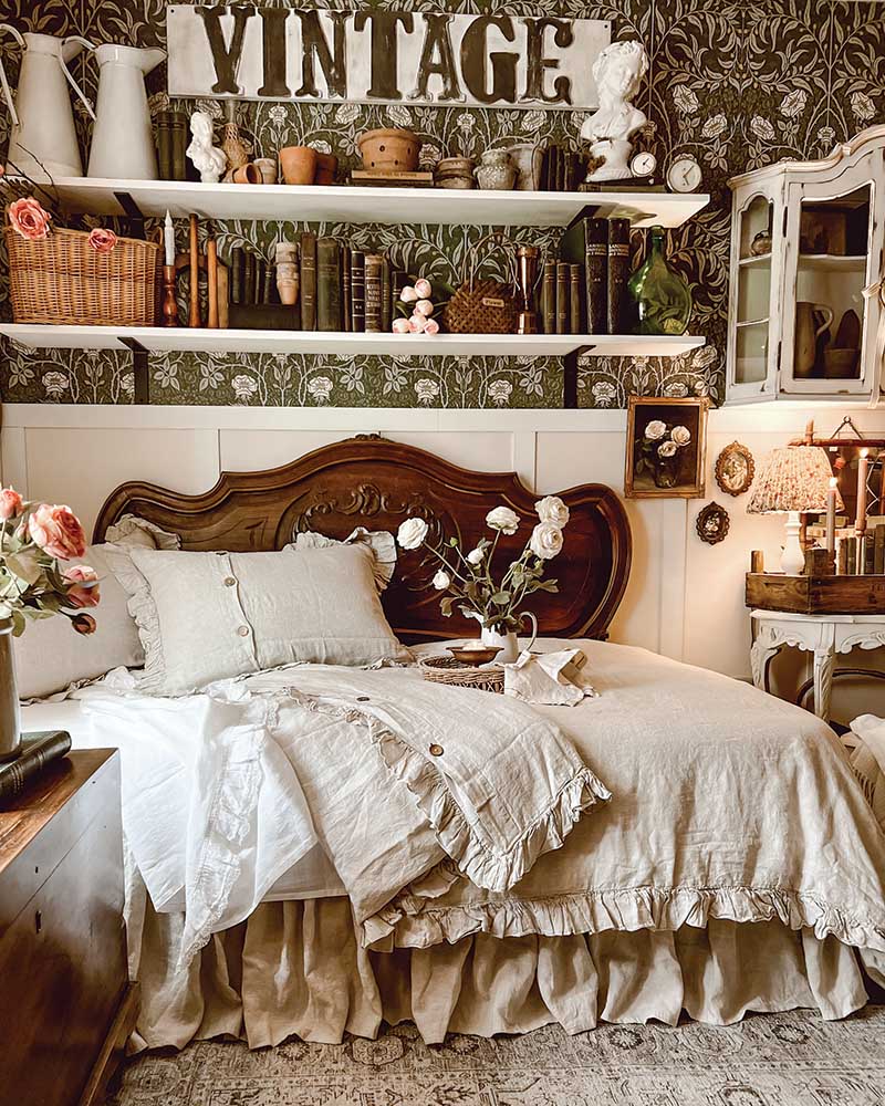A secondary bedroom doubles as a spot for overnight guests and SJ’s craft room, where she paints furniture and fashions wreaths. Serving as a headboard for the daybed is a footboard she scored at a flea market. Overhead shelving shows off her other flea market finds, and the hand-painted vintage sign was one of SJ’s creative projects.