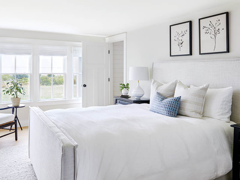 The guest room’s soothing neutral base gains appeal from a gently used but unexpected accent color. “We added black in a few accent furniture pieces to ground an overall light aesthetic,” Angela says. “Mixing black accents into a white design adds dimension and interest when used intentionally.”