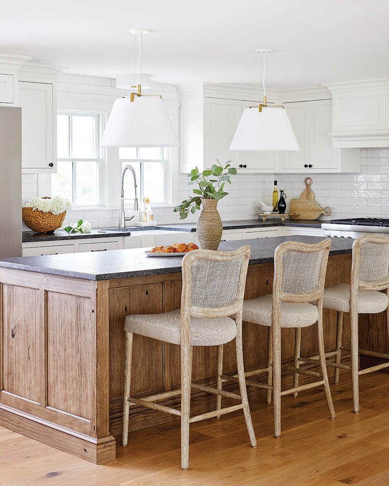 In the kitchen, dark countertops and a wood island provide contrast and depth that infuse a distinctive feel without distracting from the signature look.