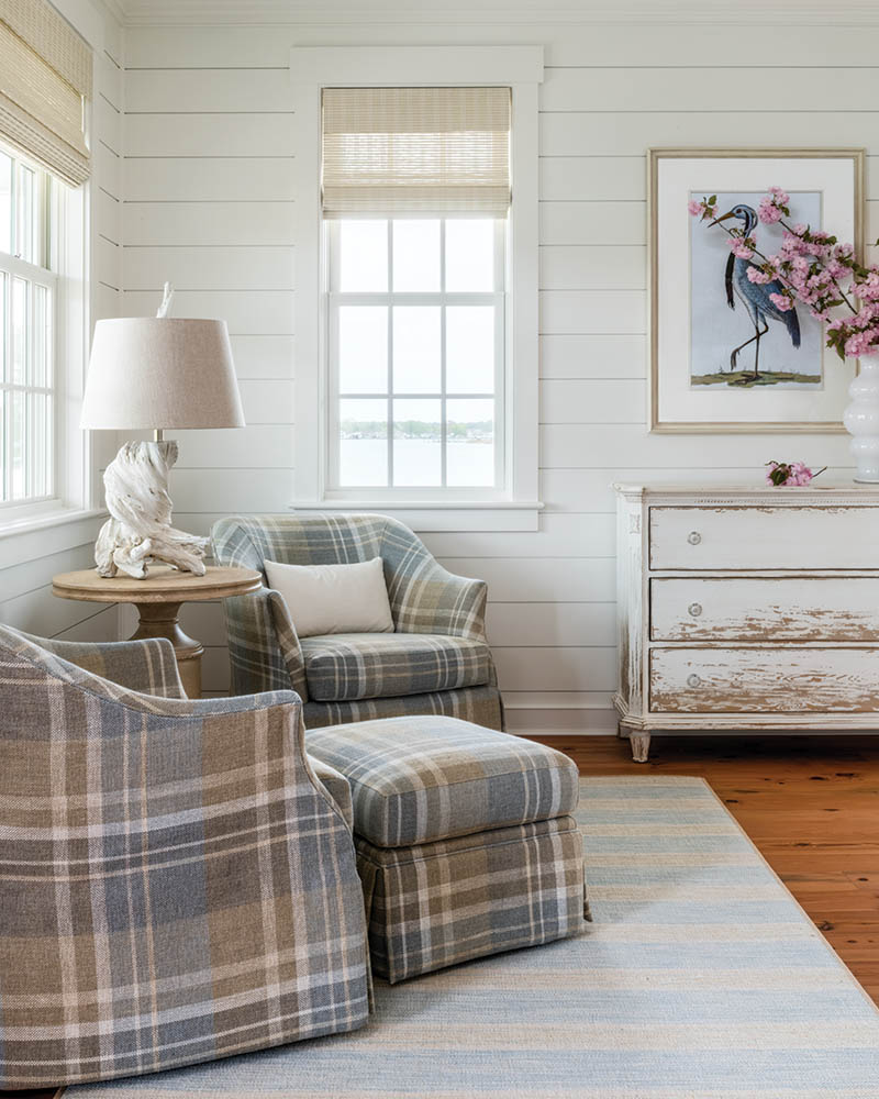 A stylish mix of stripes and checks in throw pillows combine nautical and country styles, perfect for the rural waterfront setting.