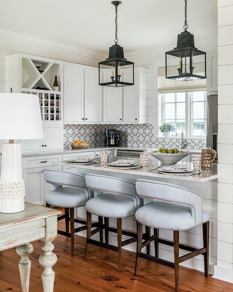 The open-plan kitchen has barstools for easy indoor meals on inclement days—or simply for breakfast. The island lanterns add spatial definition to the kitchen area.
