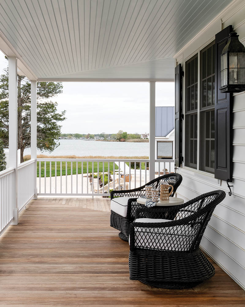 Melanie furnished the porch with dark faux wicker and contrasting white cushions with espresso-brown piping, making the wraparound porch one for prime lingering while soaking up the serene views.