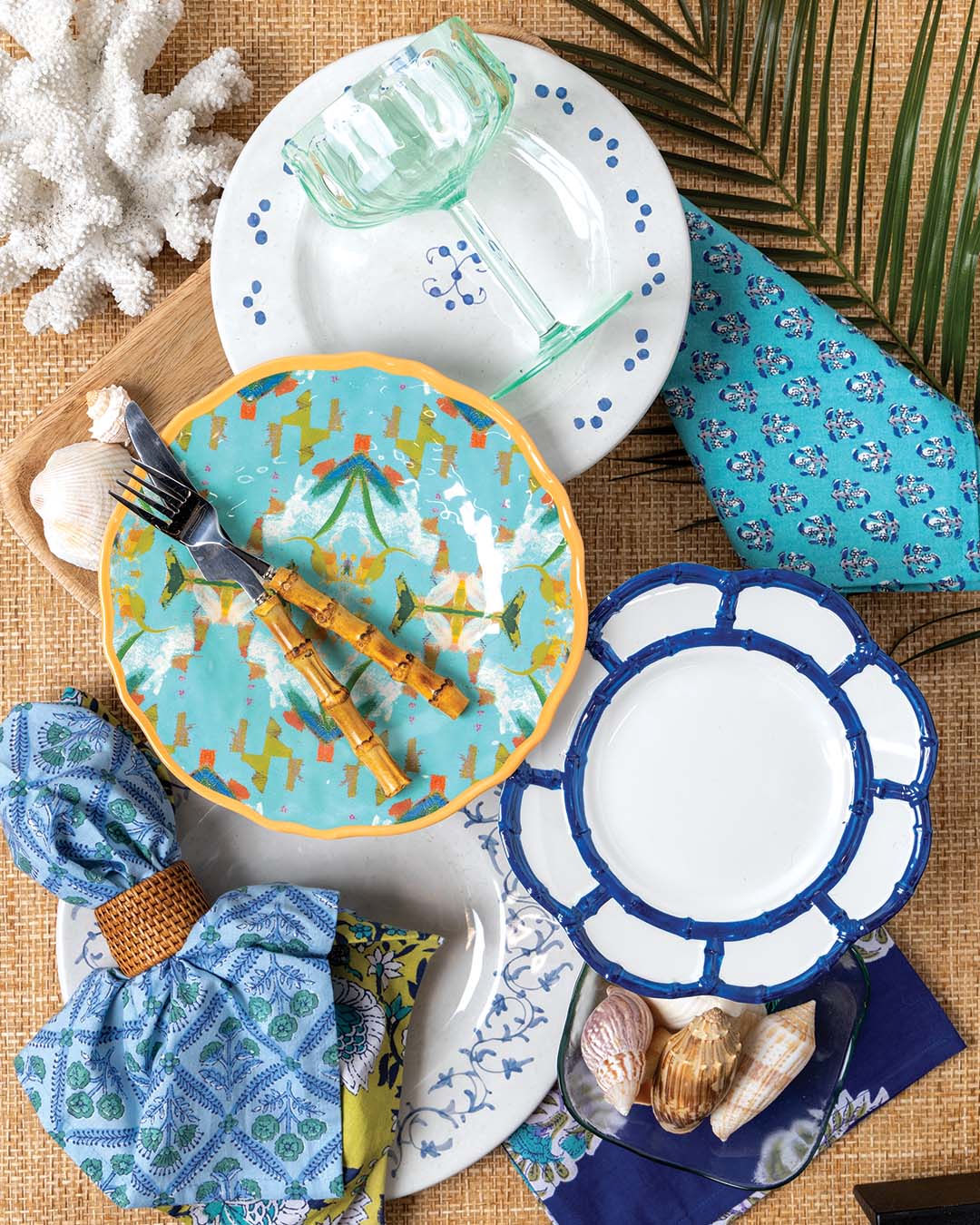 Napkins and coupe glass from Anthropologie. Blue-and-white dinner plates from Beatriz Ball. Bamboo salad plate from Kathy Kuo Home. Side plate from Laura Park Designs.