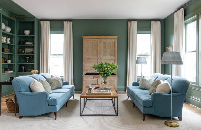 Farrow & Ball’s Green Smoke beautifully backs a Swedish cabinet used to conceal the TV as well as the antique apothecary jars and vintage paintings that occupy the built-in bookshelves. “At night, this room is so lovely,” Minnette says.