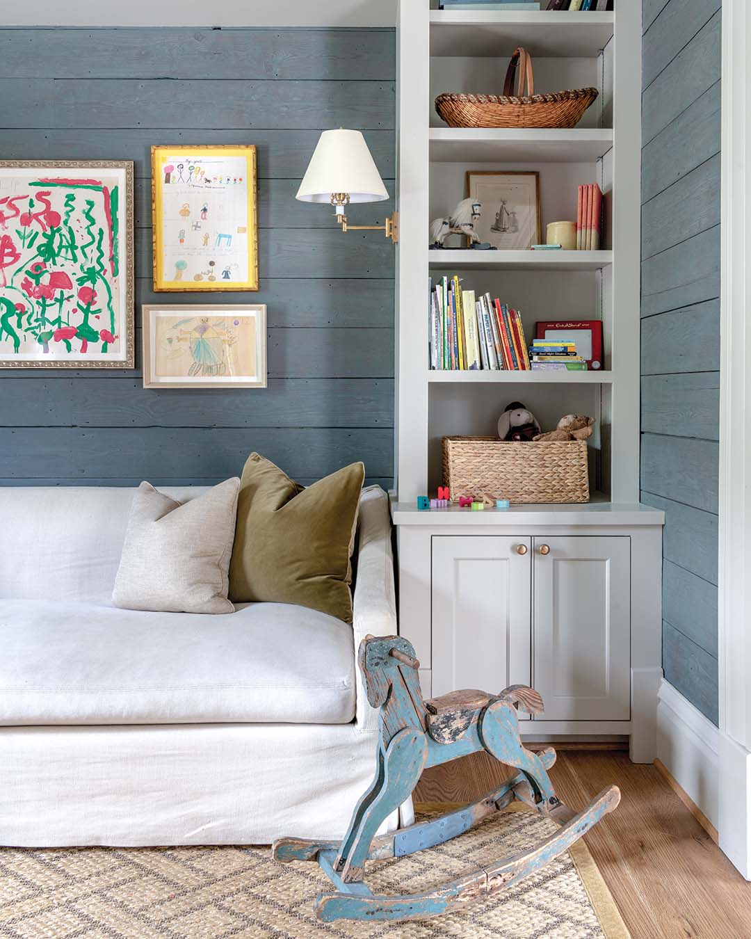 Currently used as a playroom, this space equipped with built-in shelves and a sofa was designed to grow with the family, as it will easily convert into a home office down the road.