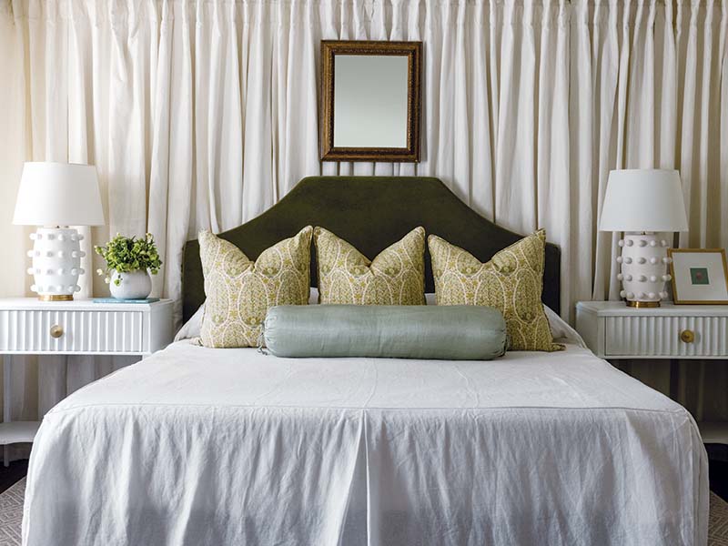 Dodging window placements, Leigh placed the bed in the back and added dramatic dimension by draping the wall and running it around the adjacent exterior side.