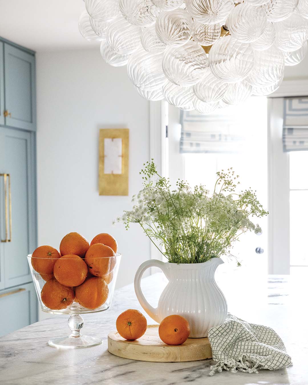 The grandeur of a waterfall island is only eclipsed by the striking statement light fixture.