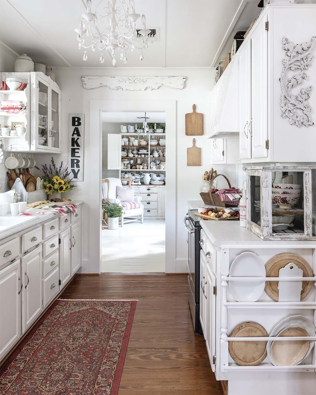 The galley kitchen utilizes a mix of covered and glass-front cabinets and open shelving to help strike a balance between creating display space for the pieces Patty cherishes while also keeping clutter to a minimum in the narrow room.