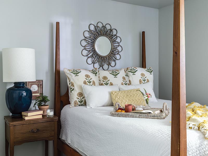 The primary bedroom takes on a sunny scheme with yellow accessories paired with crisp white linens.