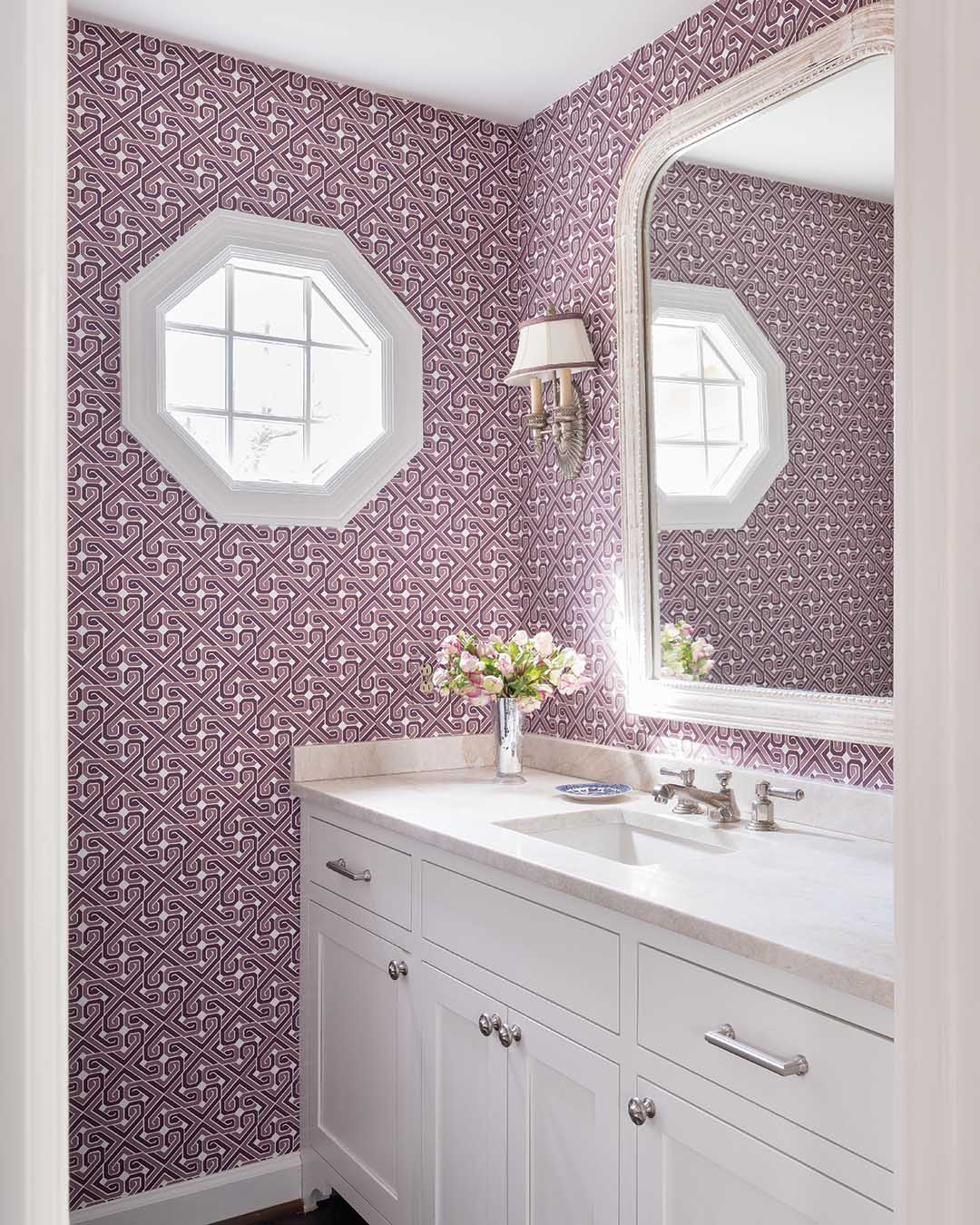 With vibrant purple geometric wallpaper, an updated vanity, and fresh hardware, the stylish powder room is both functional and fun.