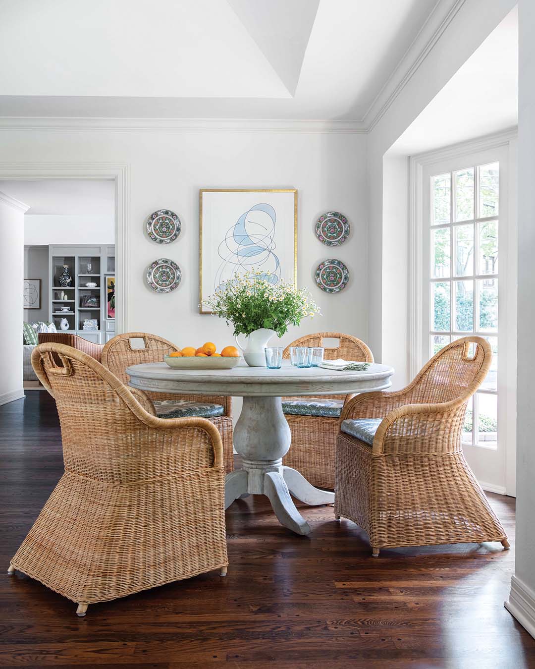 The pedestal table belonged to the homeowners prior to the move—to work it into the design, Katie paired it with woven chairs and artwork that complements its weathered finish.