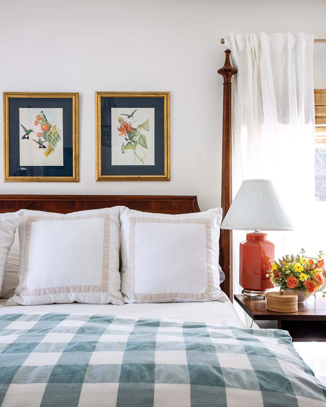 Over the primary bed, Suzanne updated a pair of prints from the 1980s by painting the mats a bold navy. A secondhand lamp on the antique bedside table pulls out the orange accents in the artwork, demonstrating her knack for making her favorite finds shine.