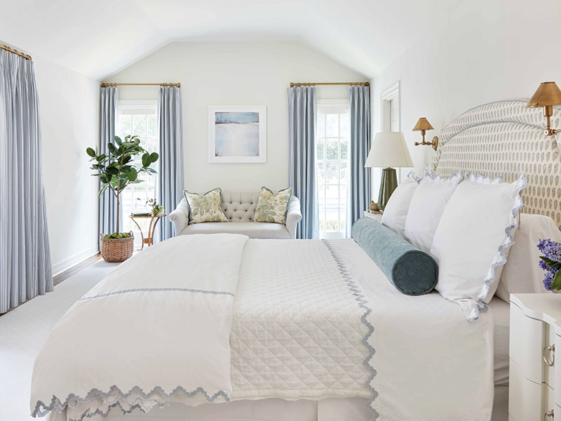 To keep the all-white walls in the bedroom from feeling cold, Katie introduced warmth in powdery blues, understated patterns, and brass accents.