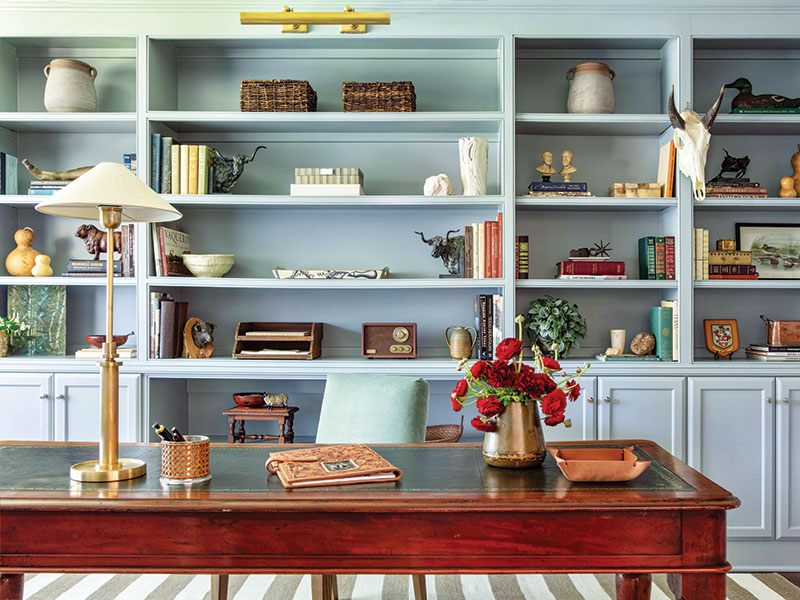 Inside the study, a graceful combination of old and new—like an antique desk atop a linear rug—offers comfort and a distinct allure.